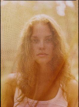 Portrait of a woman through a sheer golden curtain