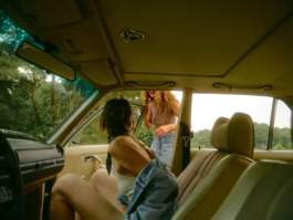 Two women inside a vintage van looking at each other