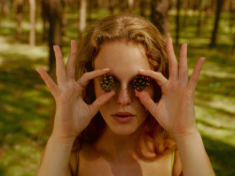 Woman holding two pinecones over her own eyes