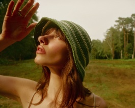Close-up of a woman shielding her eyes in a bucket hat